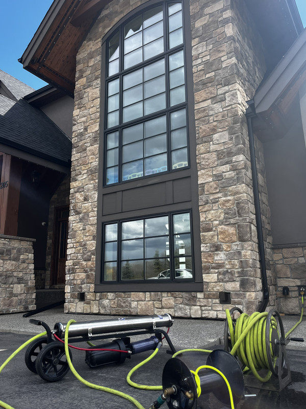 Water-fed pole reaching upper-storey windows on a Calgary custom home